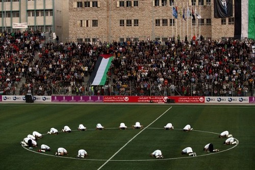 Palestinian national team kissing the ground before their first home game against Jordan