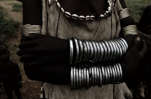 numinousnegrita:  Rich cocoa complexion under contrasting animal skin, silver bangles, arms wrapped up in gold rings, the shells…I love them. It all just pops. ♥