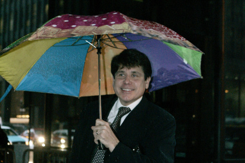 rod blagojevich umbrella. Rod Blagojevich smiles as he