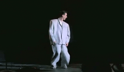 Excellent gif.  We need more inappropriate sized things in every day life.  David Byrne understands this. jesuisperdu:  (via bestrooftalkever)  David Byrne of The Talking Heads in his infamous huge suit from the film Stop Making Sense.  